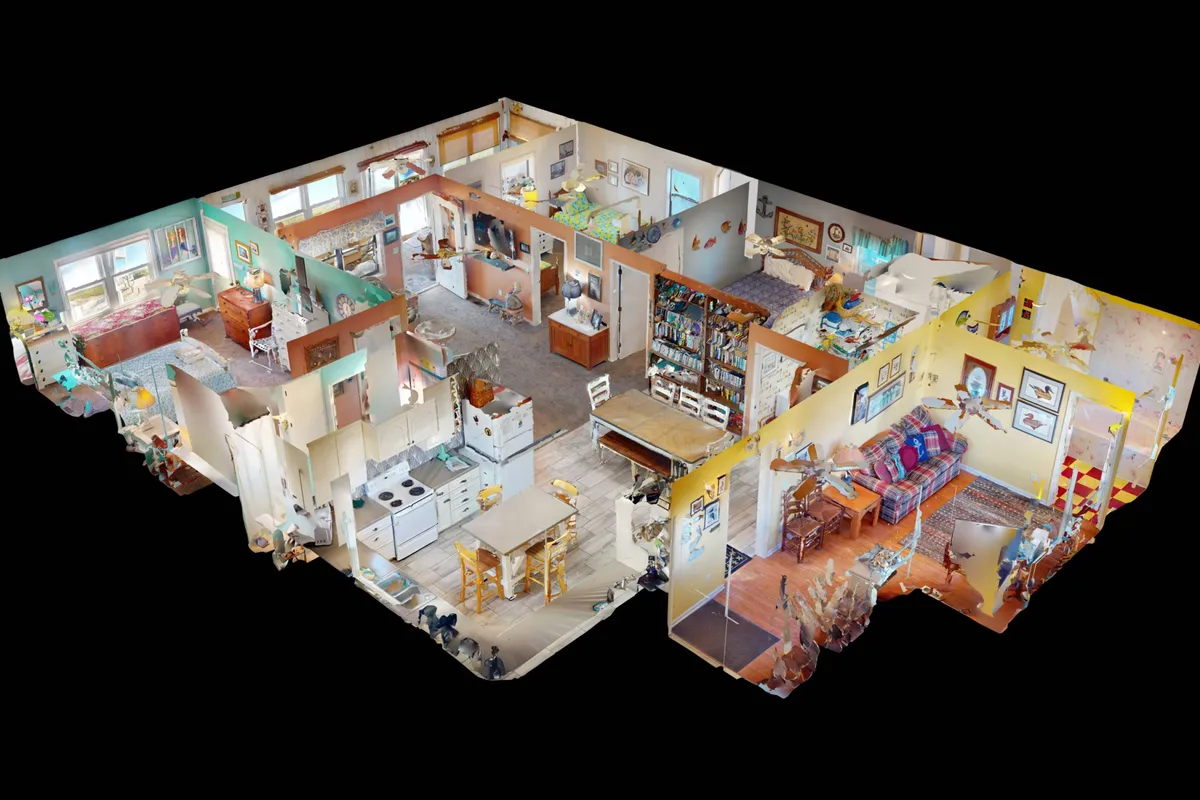 An open-plan interior showing a living area with a colorful couch, seamlessly connected to the kitchen, dining area, and a bedroom filled with natural light. The space feels cozy and ideal for family gatherings, cooking, relaxing, and enjoying time together.